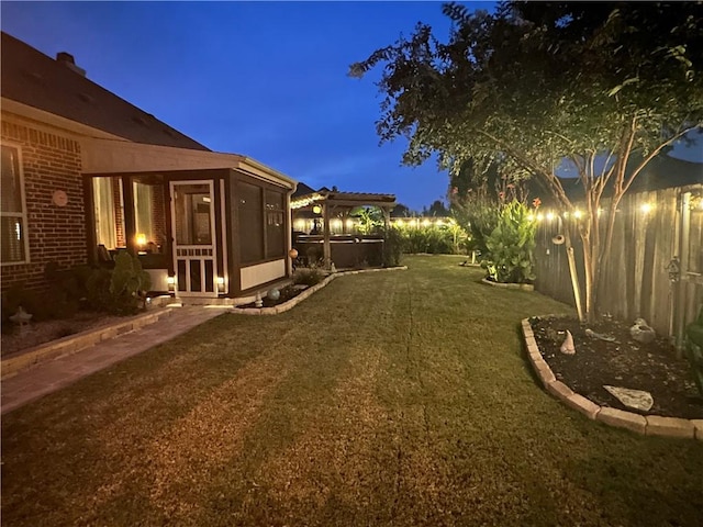 yard at dusk featuring a sunroom