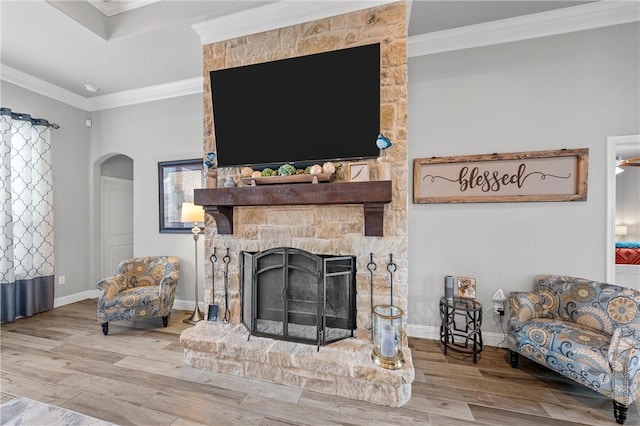 living room with a fireplace, wood-type flooring, and ornamental molding