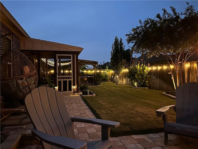 yard at dusk featuring a patio