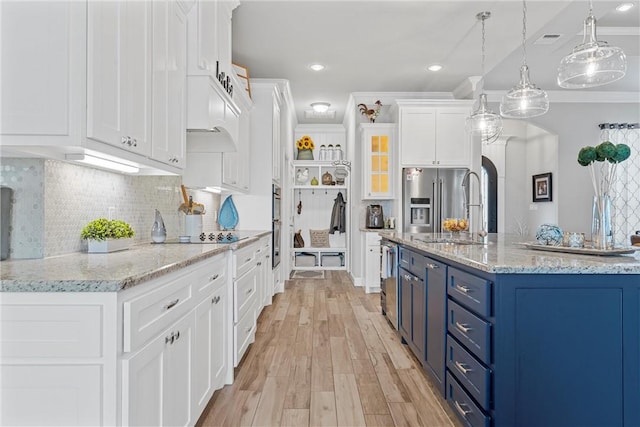 kitchen featuring backsplash, white cabinets, sink, hanging light fixtures, and blue cabinetry