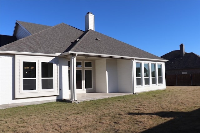 back of property with a lawn and a patio