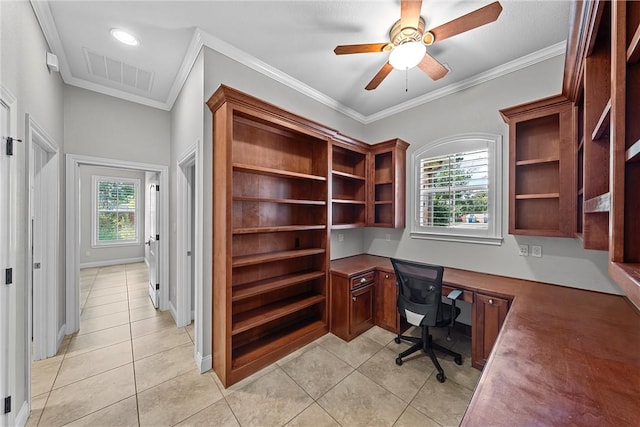 tiled home office featuring ornamental molding, built in desk, and a wealth of natural light