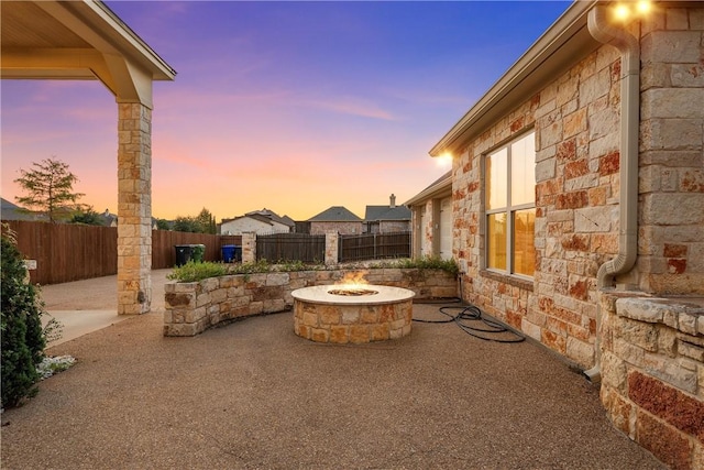 patio terrace at dusk featuring an outdoor fire pit