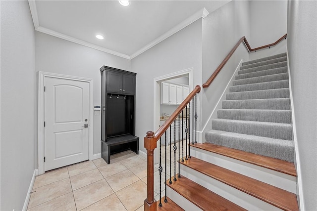 foyer entrance with crown molding and tile patterned floors