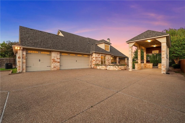 view of front of home with a garage and central air condition unit