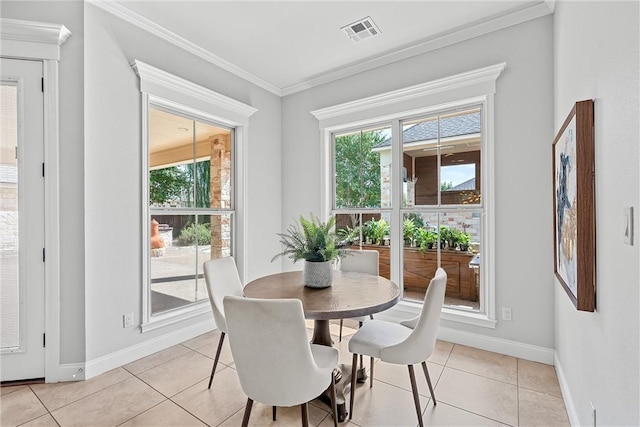 dining space featuring ornamental molding and light tile patterned flooring