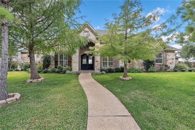 view of property hidden behind natural elements with french doors and a front lawn