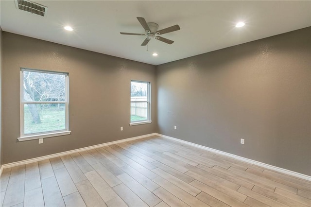 empty room with ceiling fan and light hardwood / wood-style floors