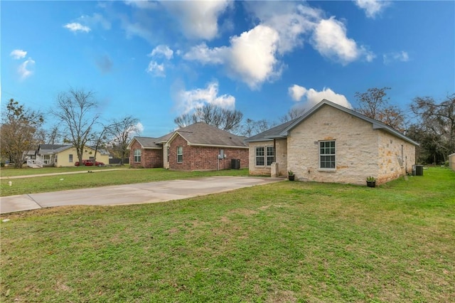 view of front of house featuring central AC unit and a front lawn