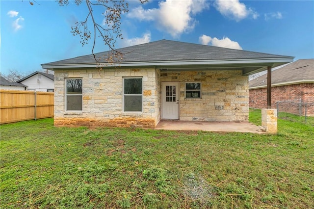 back of house featuring a lawn and a patio area