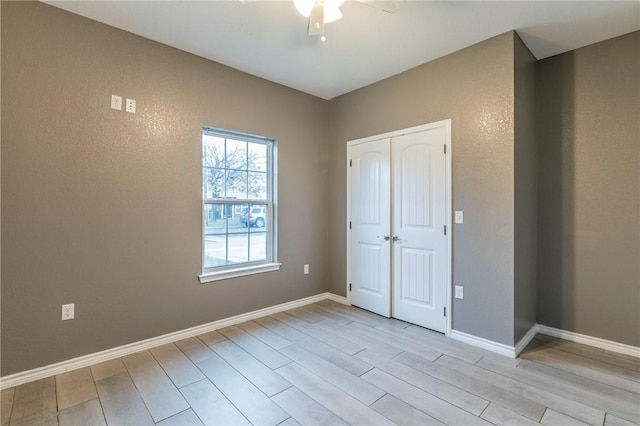 unfurnished bedroom featuring a closet, light hardwood / wood-style flooring, and ceiling fan