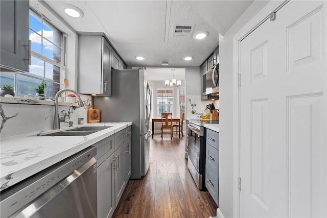 kitchen featuring appliances with stainless steel finishes, dark hardwood / wood-style floors, gray cabinets, and sink