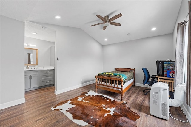 bedroom with vaulted ceiling, connected bathroom, and dark hardwood / wood-style flooring