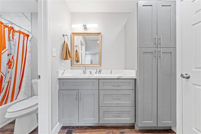 full bathroom featuring vanity, toilet, hardwood / wood-style floors, and shower / bath combo with shower curtain