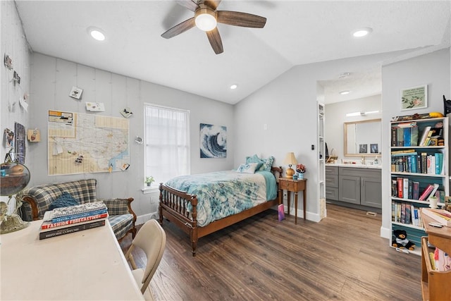 bedroom featuring vaulted ceiling, ensuite bathroom, dark hardwood / wood-style floors, sink, and ceiling fan