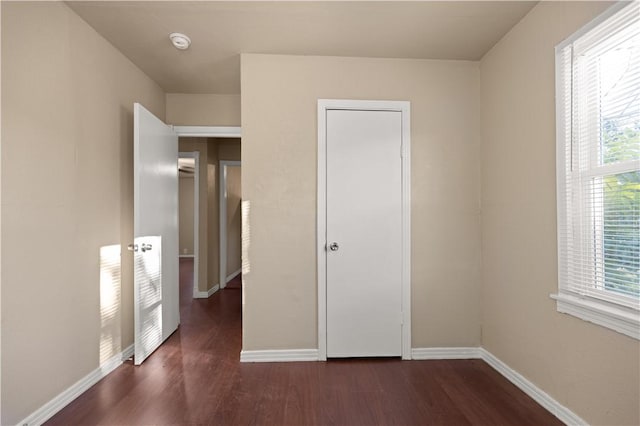 unfurnished bedroom with dark wood-type flooring