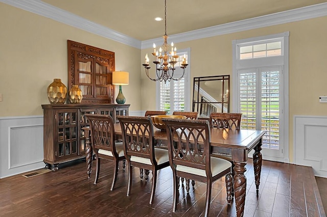 dining room featuring visible vents, dark wood-style flooring, wainscoting, crown molding, and a chandelier