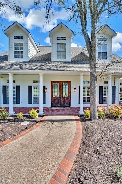 view of front facade with covered porch and a shingled roof