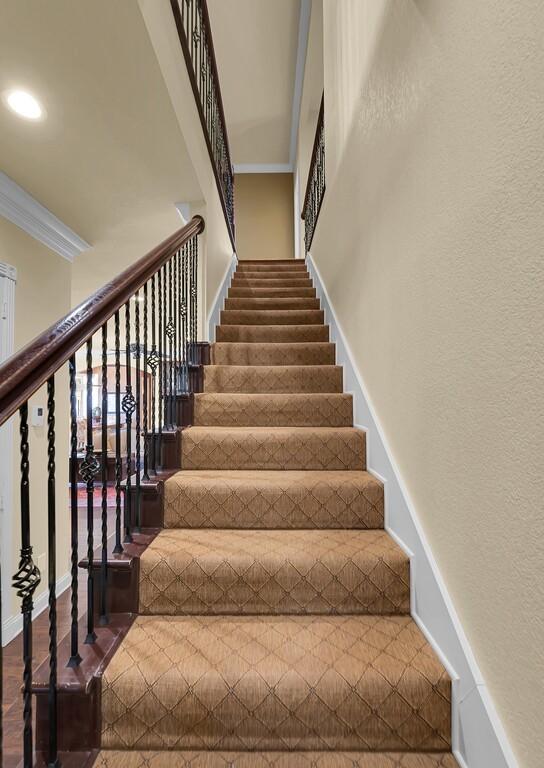 stairway with recessed lighting, baseboards, and ornamental molding