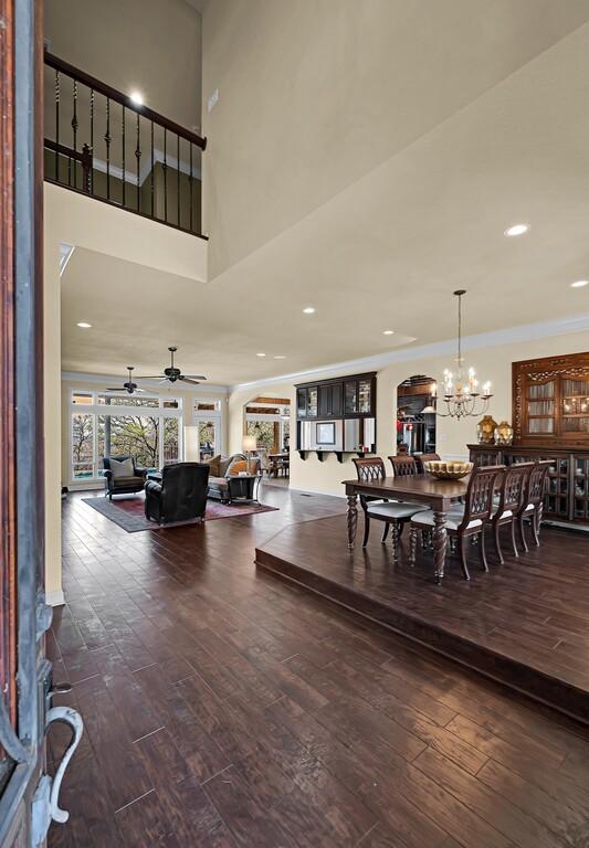 dining room featuring hardwood / wood-style floors, recessed lighting, arched walkways, crown molding, and ceiling fan with notable chandelier