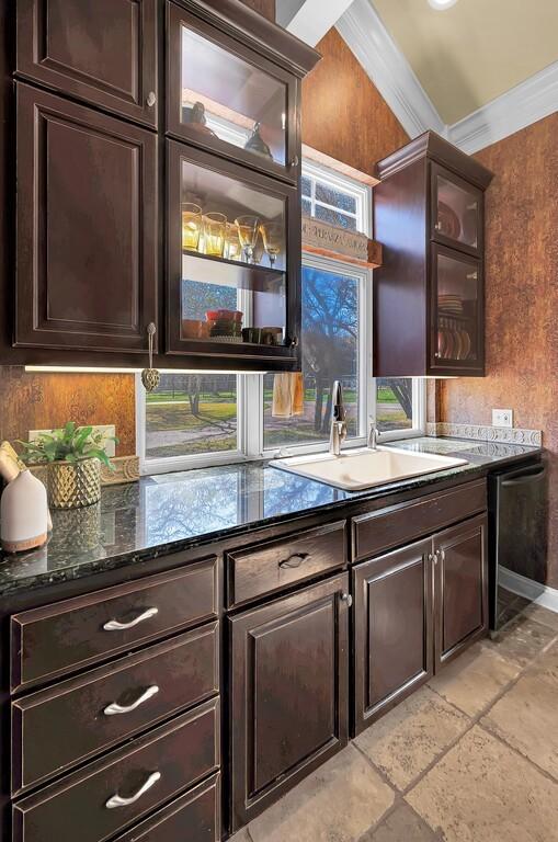 bar featuring crown molding, baseboards, stone tile floors, dishwashing machine, and a sink