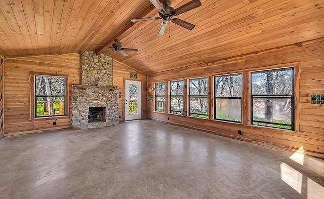 unfurnished living room with lofted ceiling, wooden walls, concrete floors, and ceiling fan