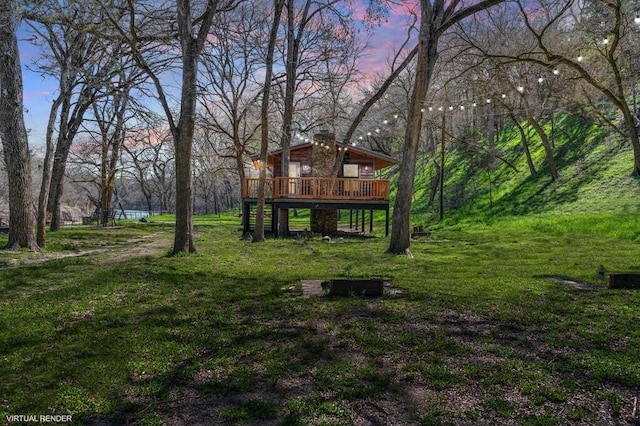 yard at dusk featuring a deck