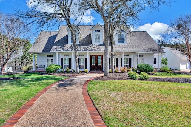 view of front of home with french doors, a front yard, and a shingled roof