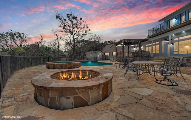 view of swimming pool featuring a pool with connected hot tub, fence, an outdoor fire pit, a pergola, and a patio