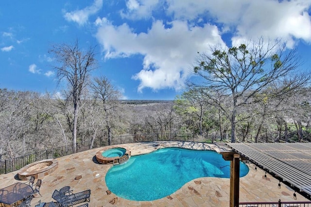 view of pool featuring a patio area, a pool with connected hot tub, and fence