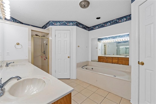 bathroom with a textured ceiling, a sink, and tile patterned floors