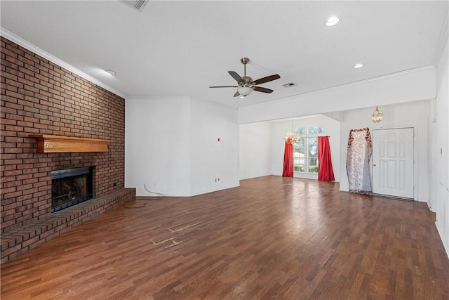 unfurnished living room with ornamental molding, a brick fireplace, and wood finished floors