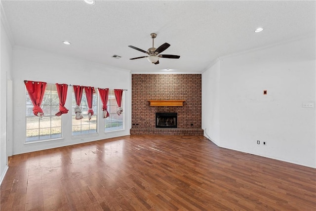 unfurnished living room featuring a textured ceiling, a fireplace, and wood finished floors