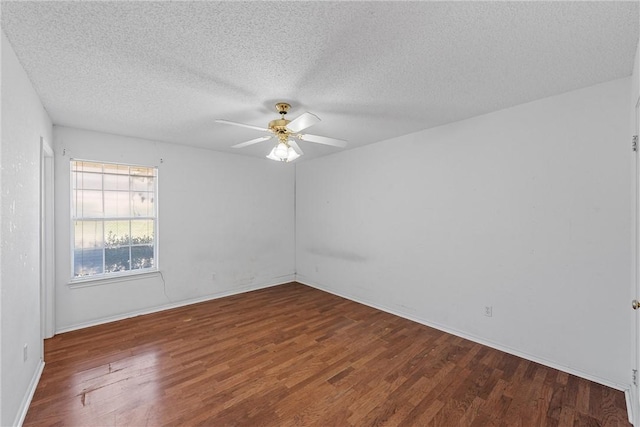 empty room with ceiling fan, a textured ceiling, wood finished floors, and baseboards