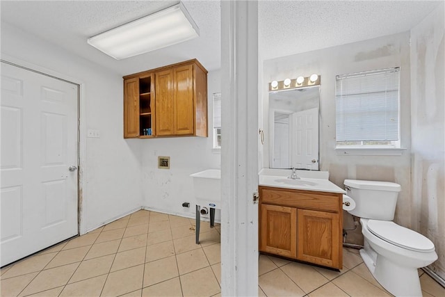 bathroom featuring toilet, vanity, a textured ceiling, and tile patterned floors