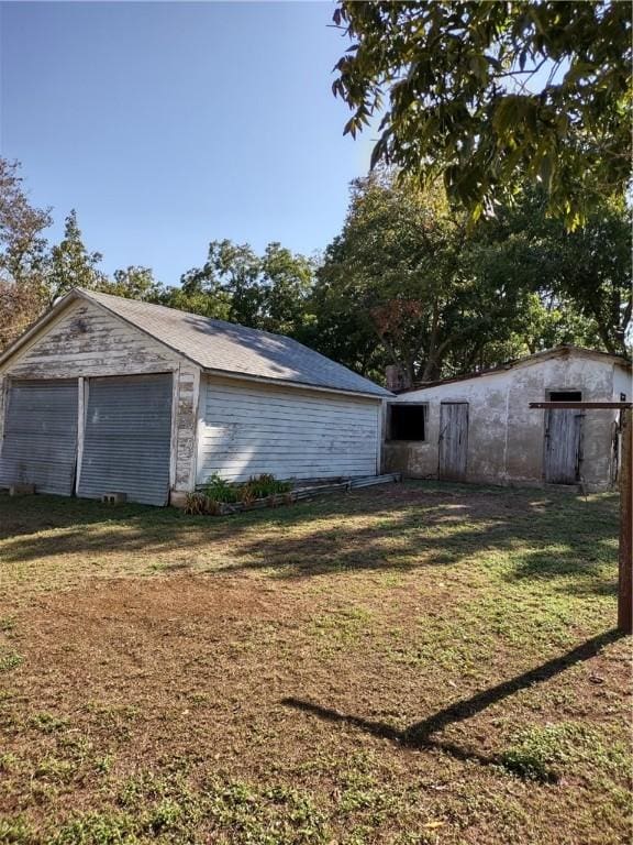 exterior space featuring an outbuilding, a yard, and a garage