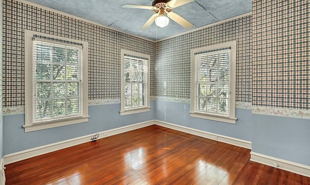 unfurnished room featuring a wealth of natural light, ceiling fan, and hardwood / wood-style flooring