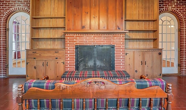 tiled living room with brick wall and a brick fireplace