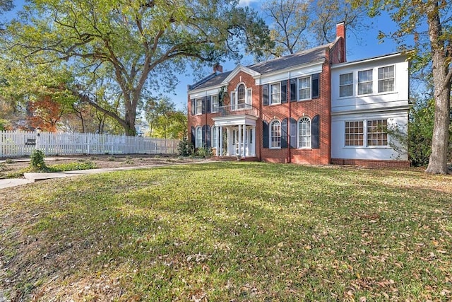 colonial-style house with a balcony and a front lawn