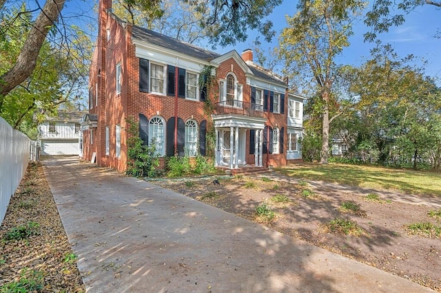 view of front facade featuring a balcony, an outdoor structure, and a garage