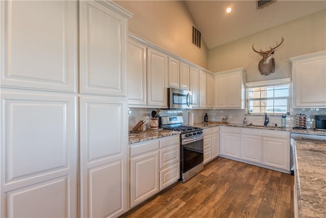 kitchen featuring decorative backsplash, stainless steel appliances, white cabinetry, and sink