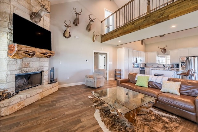 living room featuring a fireplace, high vaulted ceiling, and hardwood / wood-style flooring