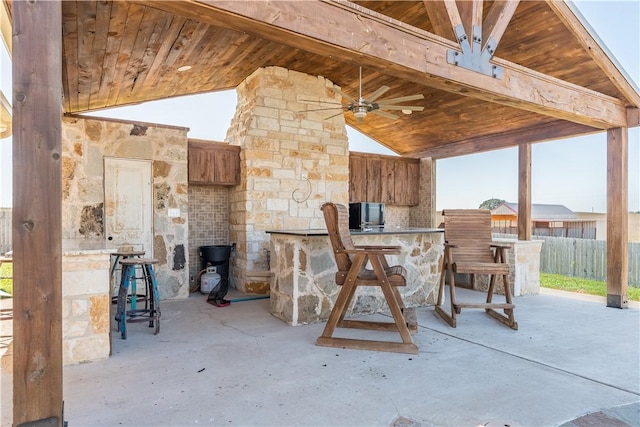 view of patio with exterior bar and ceiling fan