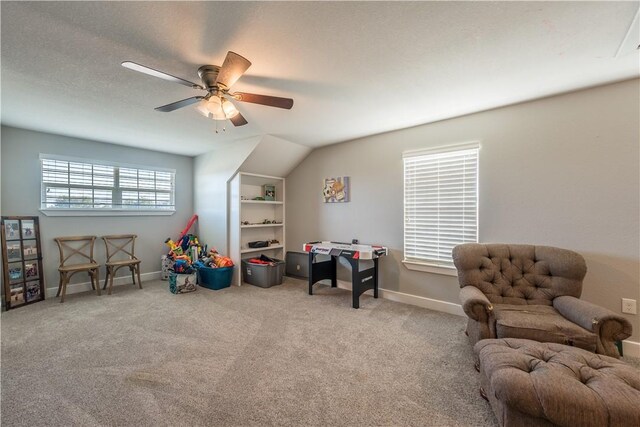 rec room with a textured ceiling, ceiling fan, light carpet, and vaulted ceiling