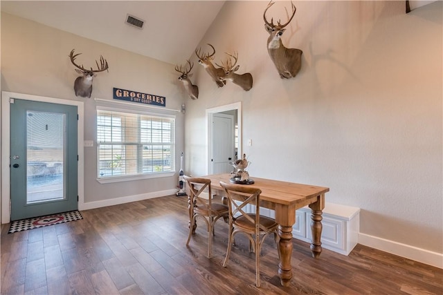 dining room featuring dark hardwood / wood-style flooring and vaulted ceiling