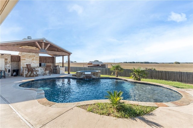 view of pool with an in ground hot tub, an outdoor kitchen, and a patio