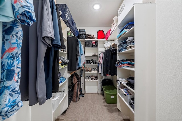 walk in closet featuring carpet flooring