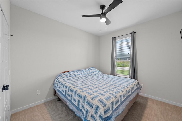 carpeted bedroom featuring ceiling fan and baseboards