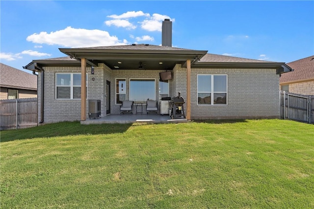 back of house featuring brick siding, a yard, a patio, cooling unit, and a fenced backyard