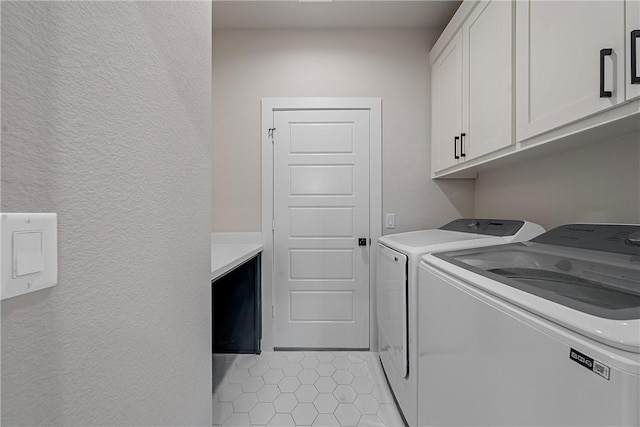 washroom featuring cabinet space, independent washer and dryer, and light tile patterned floors